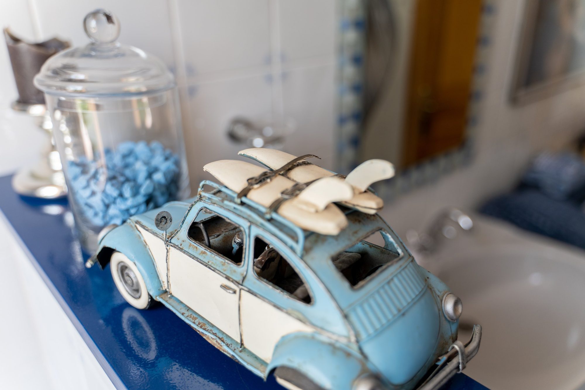 Coche clásico de hojalata sobre el mueble de la entrada